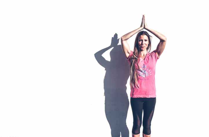 woman in pink crew neck t shirt and black leggings standing near white wall